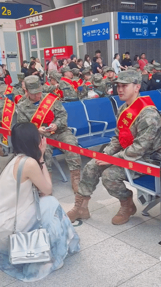 一名年轻女孩在火车站送别参军入伍的男朋友。
两个人还在候车大厅里聊天说话，也不知