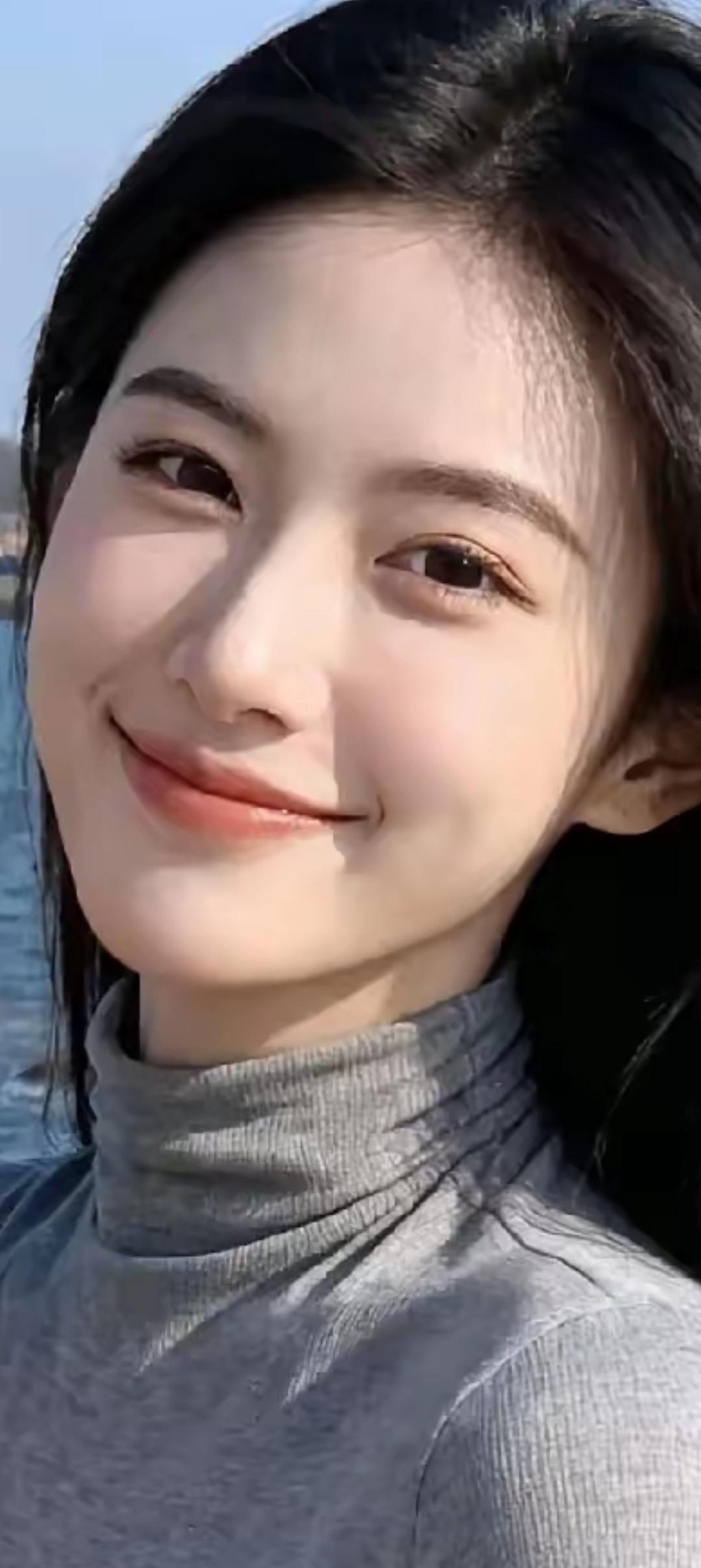 阳光明媚的一天，微笑的少女与海浪相伴。