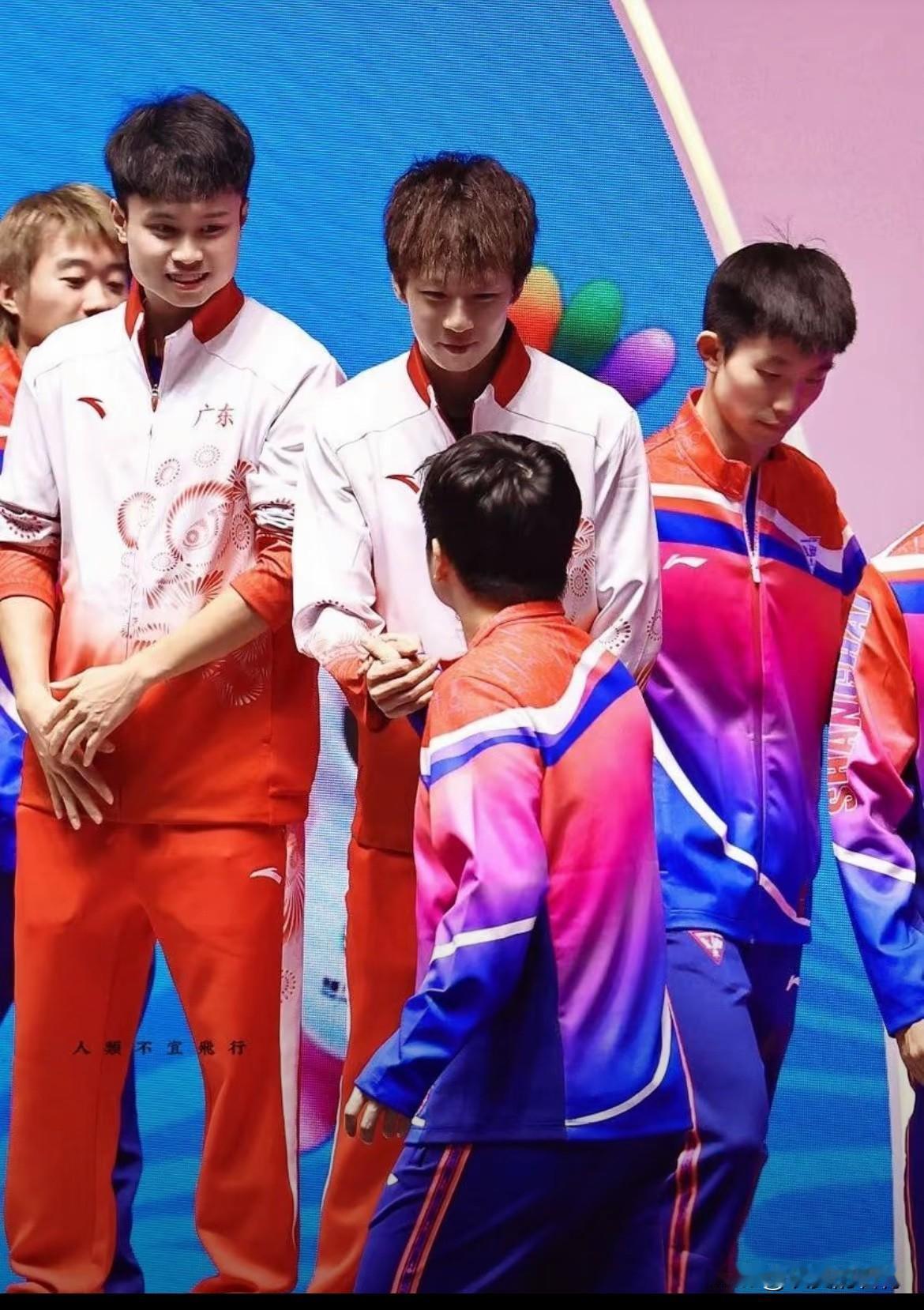 林高远、周启豪和樊振东在一起
这种照片真好看。樊振东来祝贺林高远。看高远的手，不