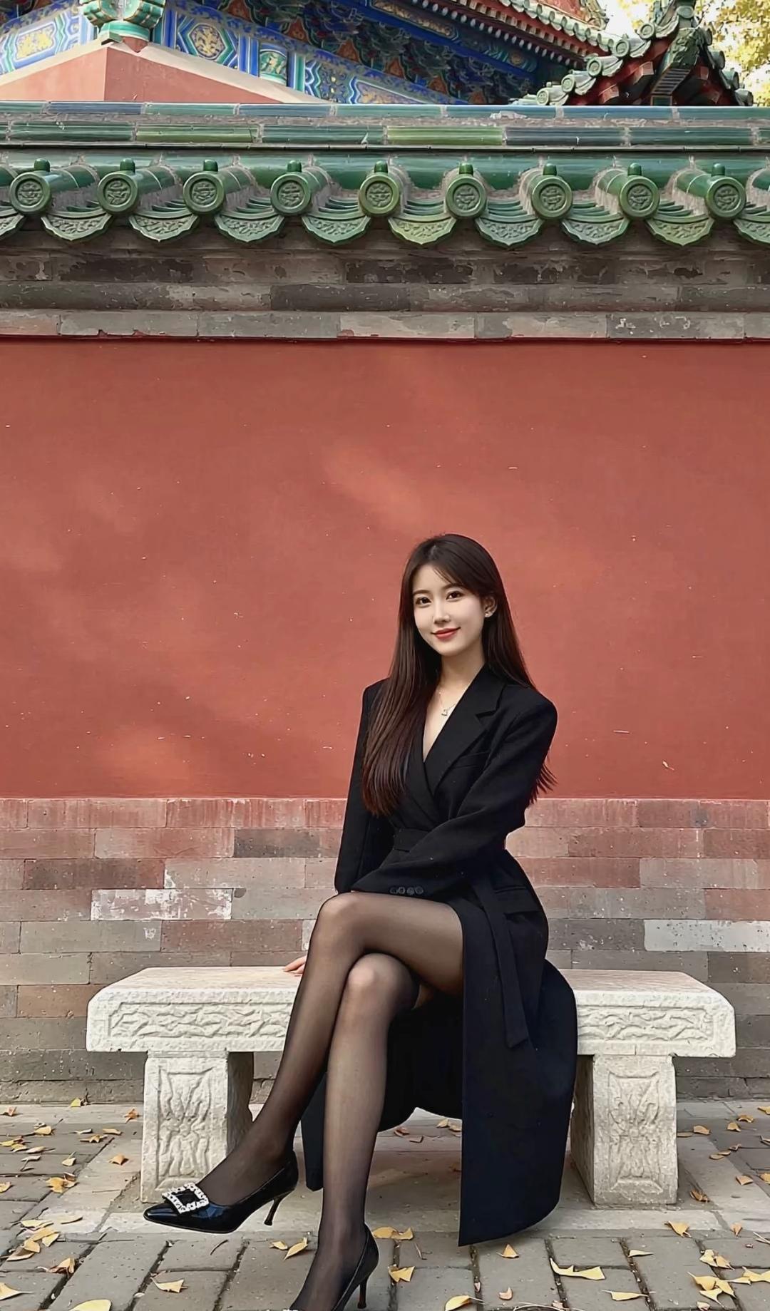 红墙绿瓦下，黑裙与秋叶相映成趣，优雅动人。