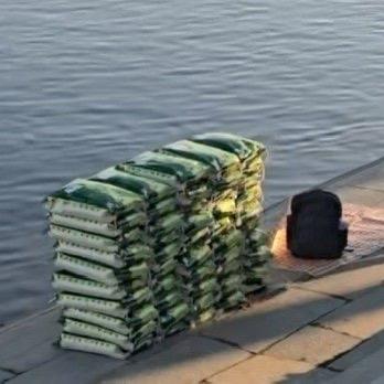 最近辽宁丹东有件事儿挺让人摸不着头脑——有网友拍到，几个人在江边摆了好几袋大米，