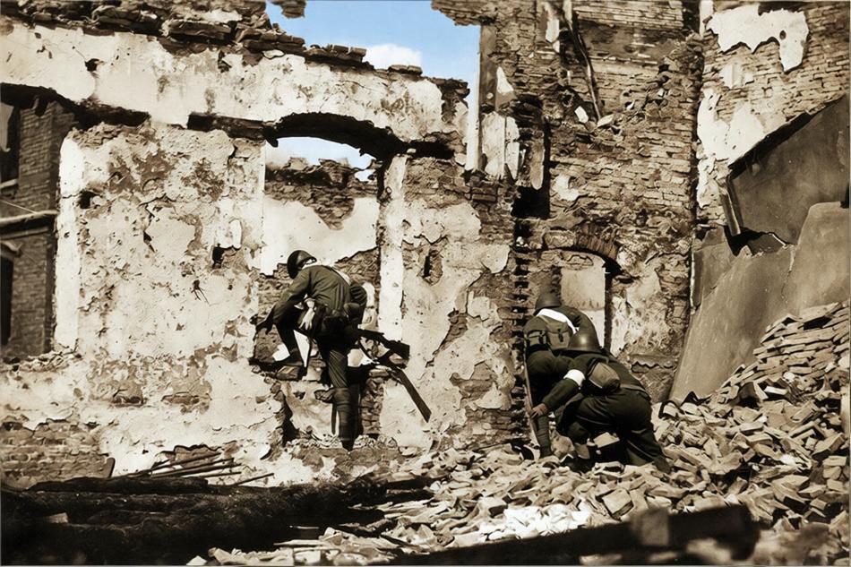 1937年，淞沪会战中，上海闸北区附近的街巷废墟中，三名鬼子兵正通过一栋严重损毁