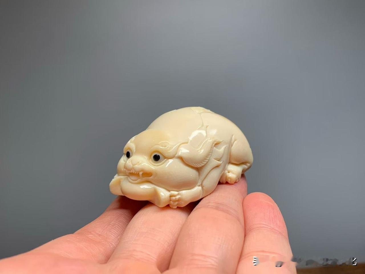 这只小貔貅，一看就讨喜。

猛犸老料圆雕而成，身形敦厚伏卧，双眼乌亮有神，嘴衔元