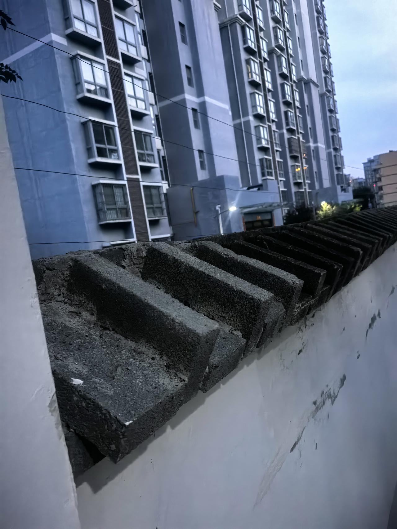 前段时间讨论因围墙顶部没有做压顶后出现的墙皮开裂处置措施，下午散步时突然发现小区