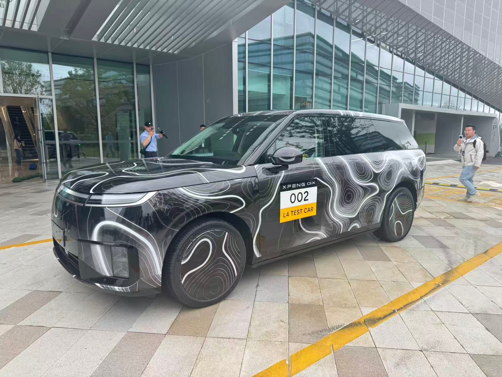 不是！这台小鹏 GX 居然是无人驾驶测试车，有一位安全员，可以忽略这位，小蓝灯亮