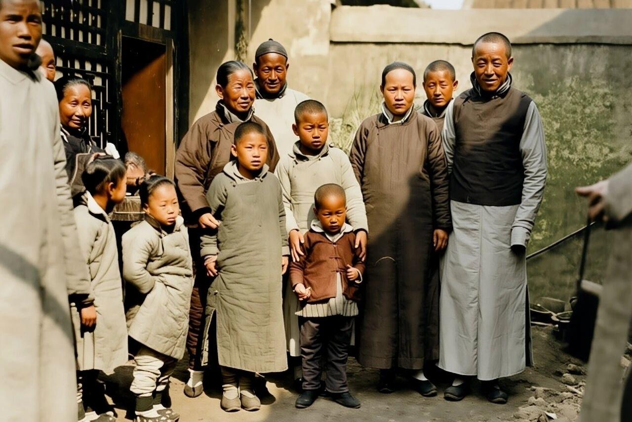 清末，北京一个大户人家13口人的合影。
照片中，每个人都穿着长短不一的棉袍，长袍