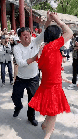 跳舞是一个开心的事，我怎么在他们俩脸上没看出来呢？
女的穿的倒挺喜庆，一身红色连