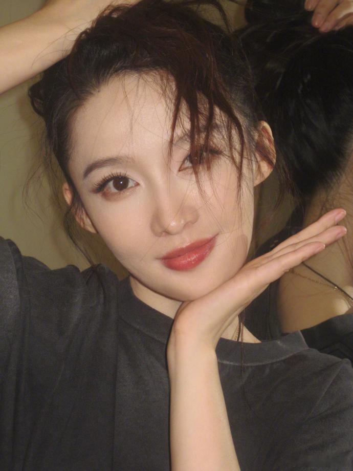 李沁自由随性的美李沁更新微博记录下班碎片，配文收工打个卡，黑T恤搭配凌乱感高马尾