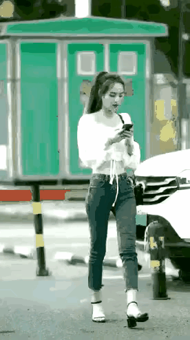 九阴白骨爪重出江湖。
       穿白衣牛仔裤的细腰美女一边走路一边看手机，突