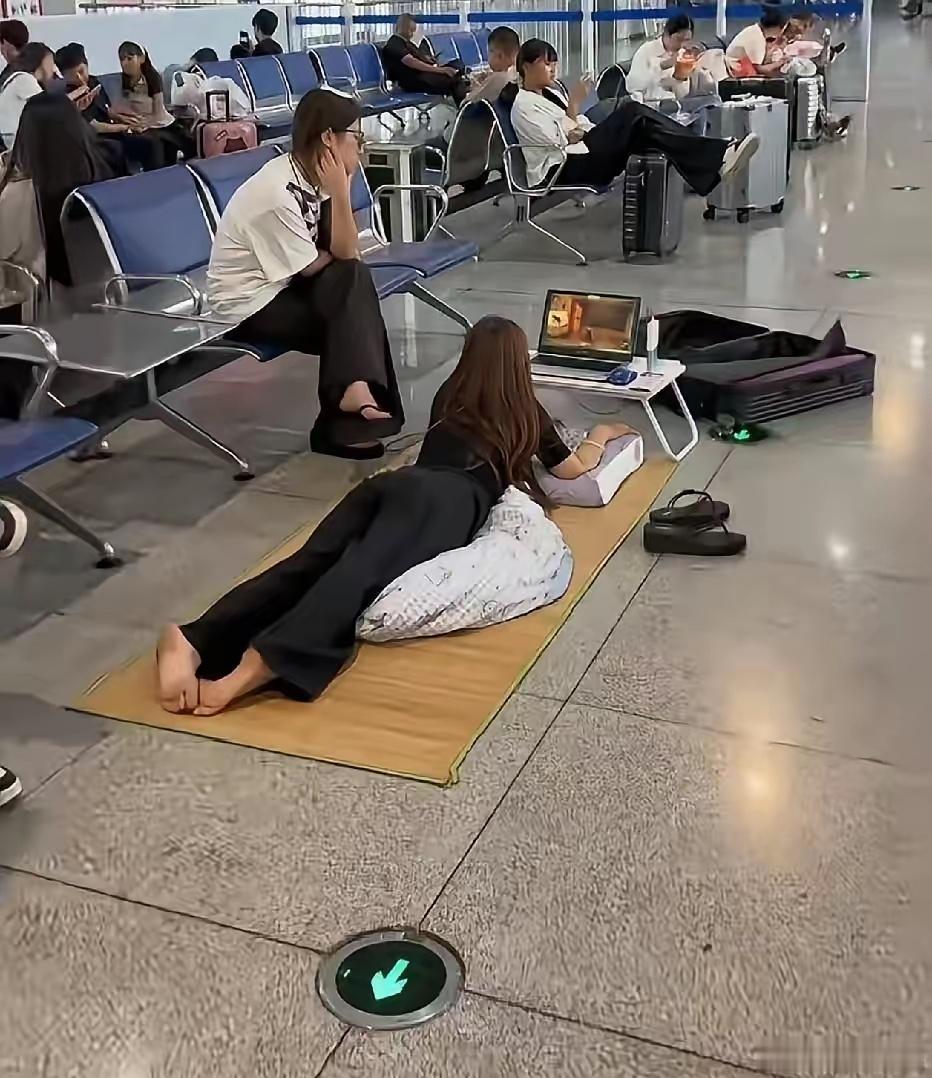 网友在候车大厅等车，一转头吓一跳，有个女生直接把凉席铺地上，枕头拖鞋全安排上，支