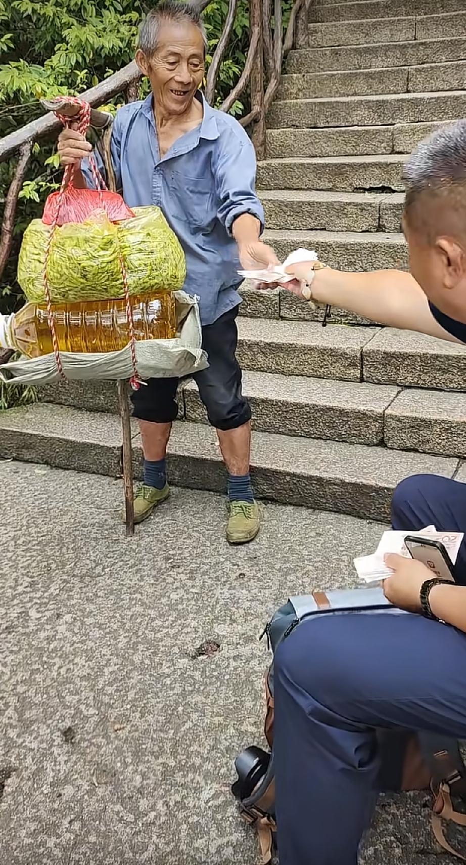 坐在山道上休息的中年男子，看到路过的挑山工，做出的一个举动，让人感动暖心了。
