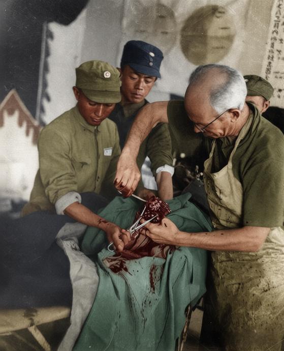 1938年，白求恩在山西五台松岩口模范病室为伤员实施手术，右侧专注操作的正是加拿
