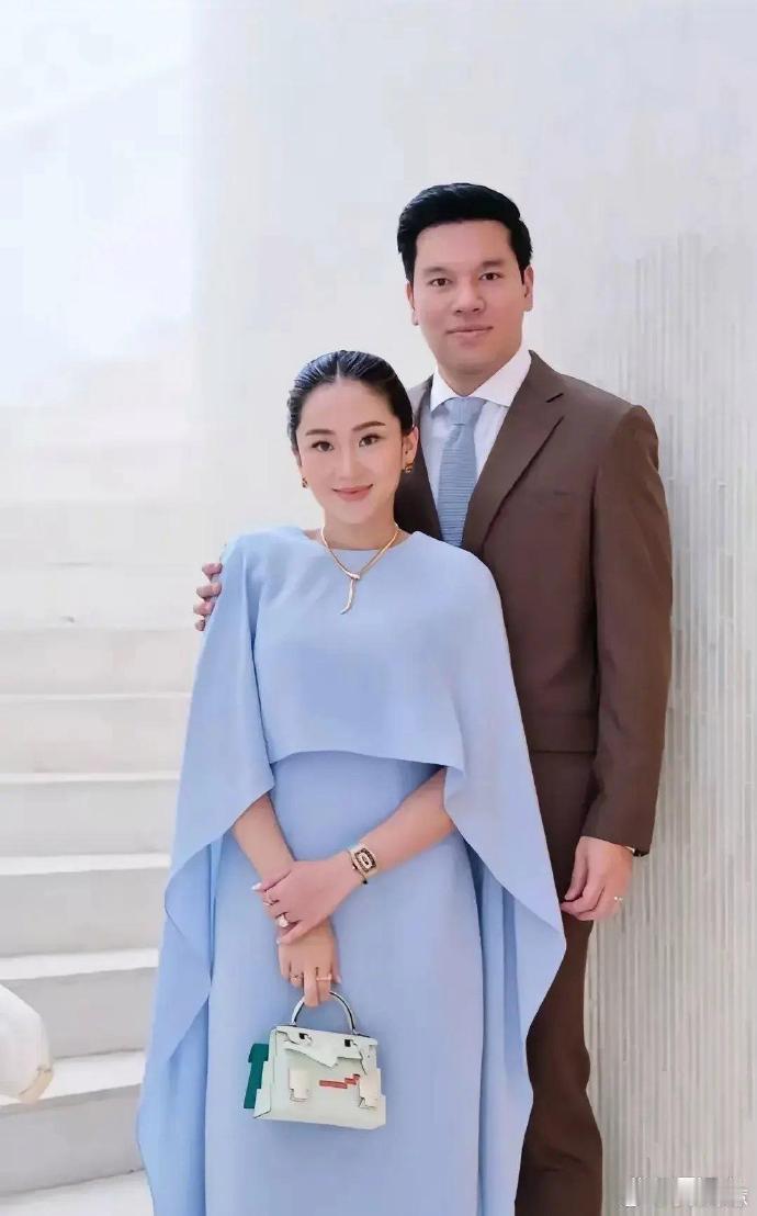 泰国女总理在丈夫面前显得温柔依赖，明显深爱着他。其夫身高约1米8以上，体格健壮，