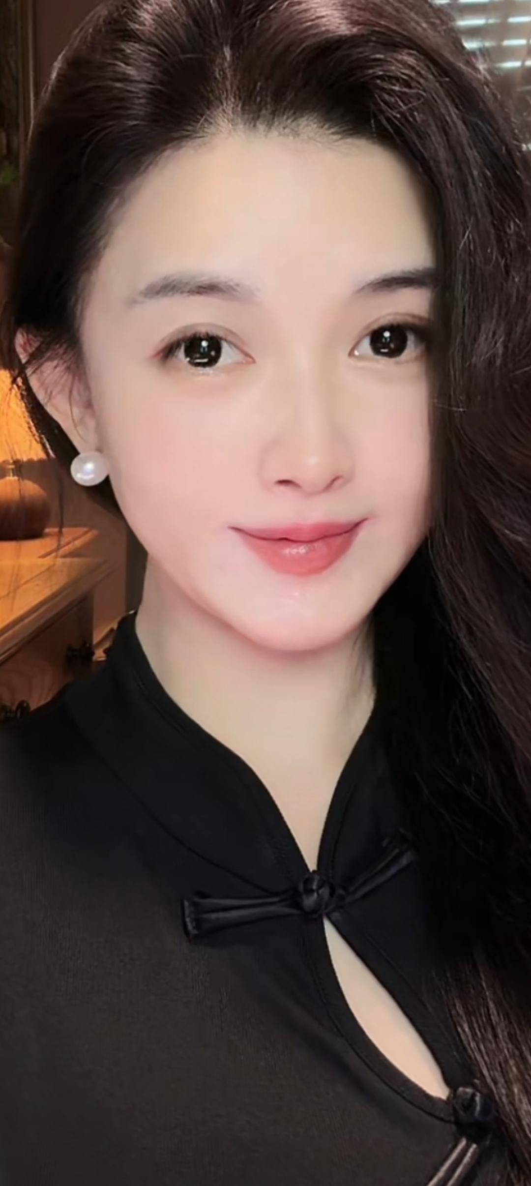 这姑娘真漂亮，珍珠耳环配黑色衣服。