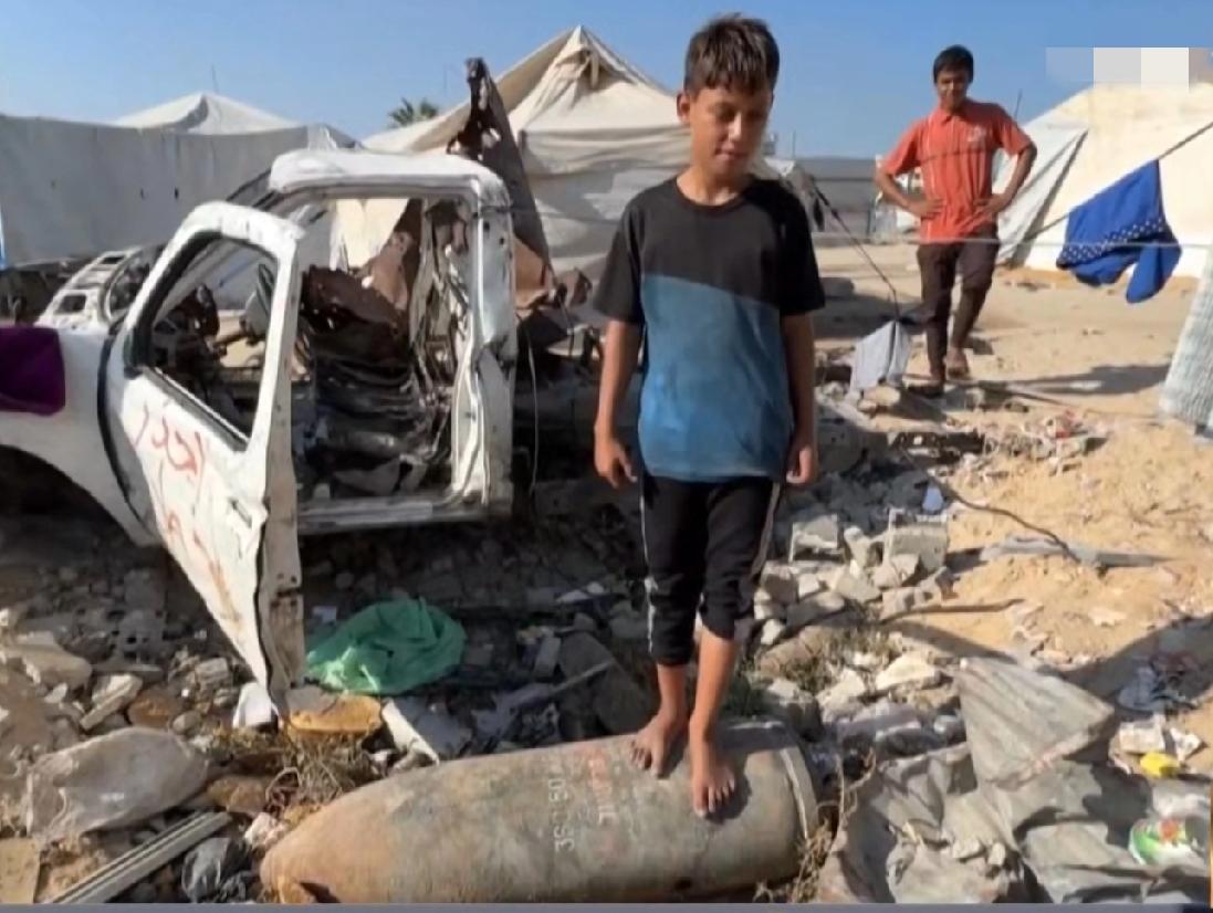 加沙的一名男孩站在一枚哑弹上面玩耍，从他的表情上看，竟然没有一丝恐慌与俱怕。
以