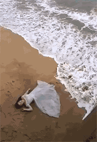 为了拍出这么有个性的照片，女子也是拼了。在海滩上，迎着潮涨潮落，等待摄影师的抓拍