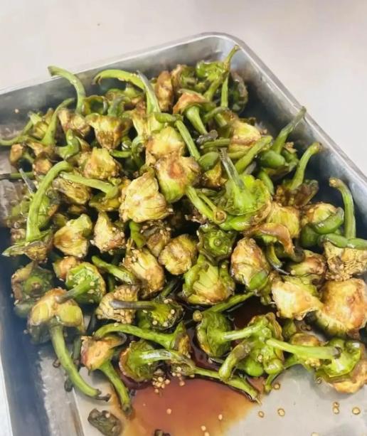 从没见过的食堂创新菜，一盘带柄青绿食材，网友猜啥的都有。
中午就餐被食堂这道菜吸