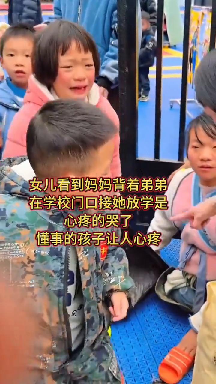 女儿看到妈妈背着弟弟在学校门口接她放学是心疼的哭了，懂事的孩子让人心疼。