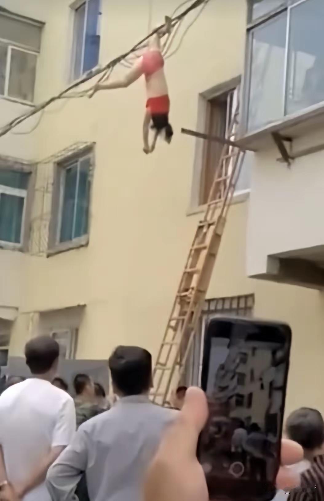 命悬一线具象化了。偷情女子跳楼逃跑，被电线挂住，还好也许能保住一条命。不过，丢人