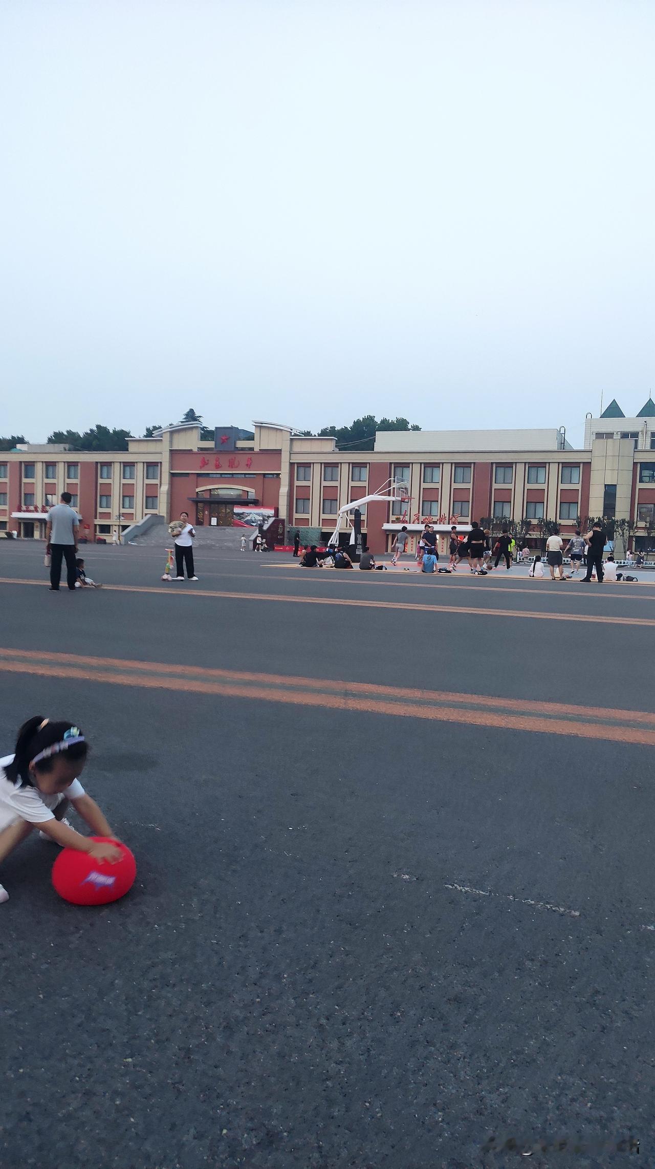 小孩在路边玩红色球球。