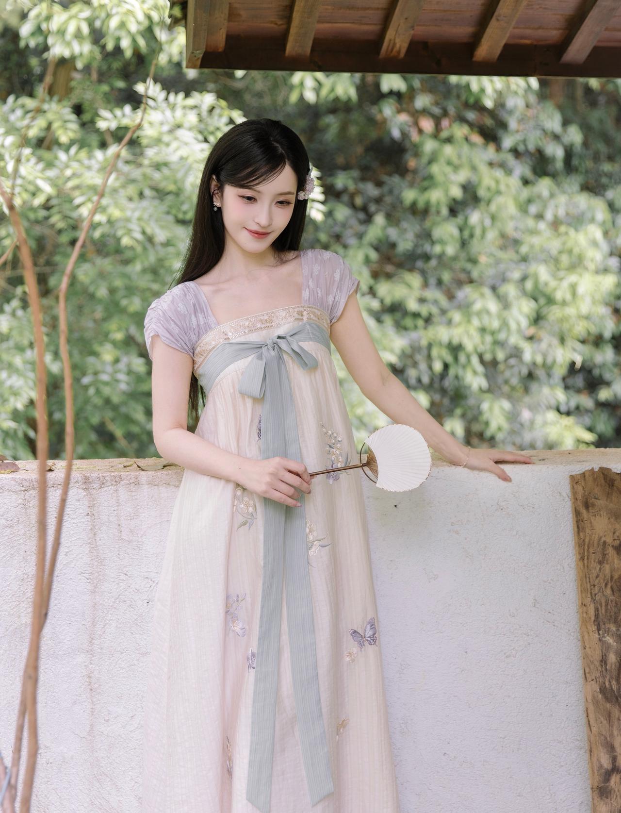 裙裾轻扬，绣满蝶与花枝，
清浅绿意晕开温柔国风，
执一把小扇，闲坐庭院，
漫享满