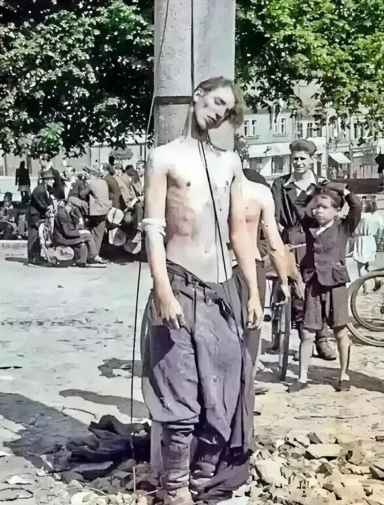 1945年，捷克斯洛伐克街头，两名纳粹士兵被套上了绞索，他们的背后是生活逐渐归入