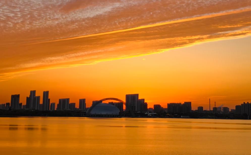 聊城东昌湖的落日，真的是一场视觉盛宴。

夕阳将天空染成绚烂的橙红与深邃的靛蓝，