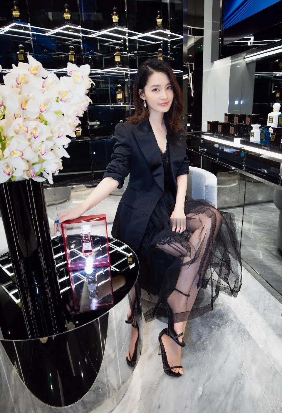 黑色代表着神秘和稳重大气！照片中的她一件黑色休闲长西服，打配上黑色薄纱裙。脚穿黑