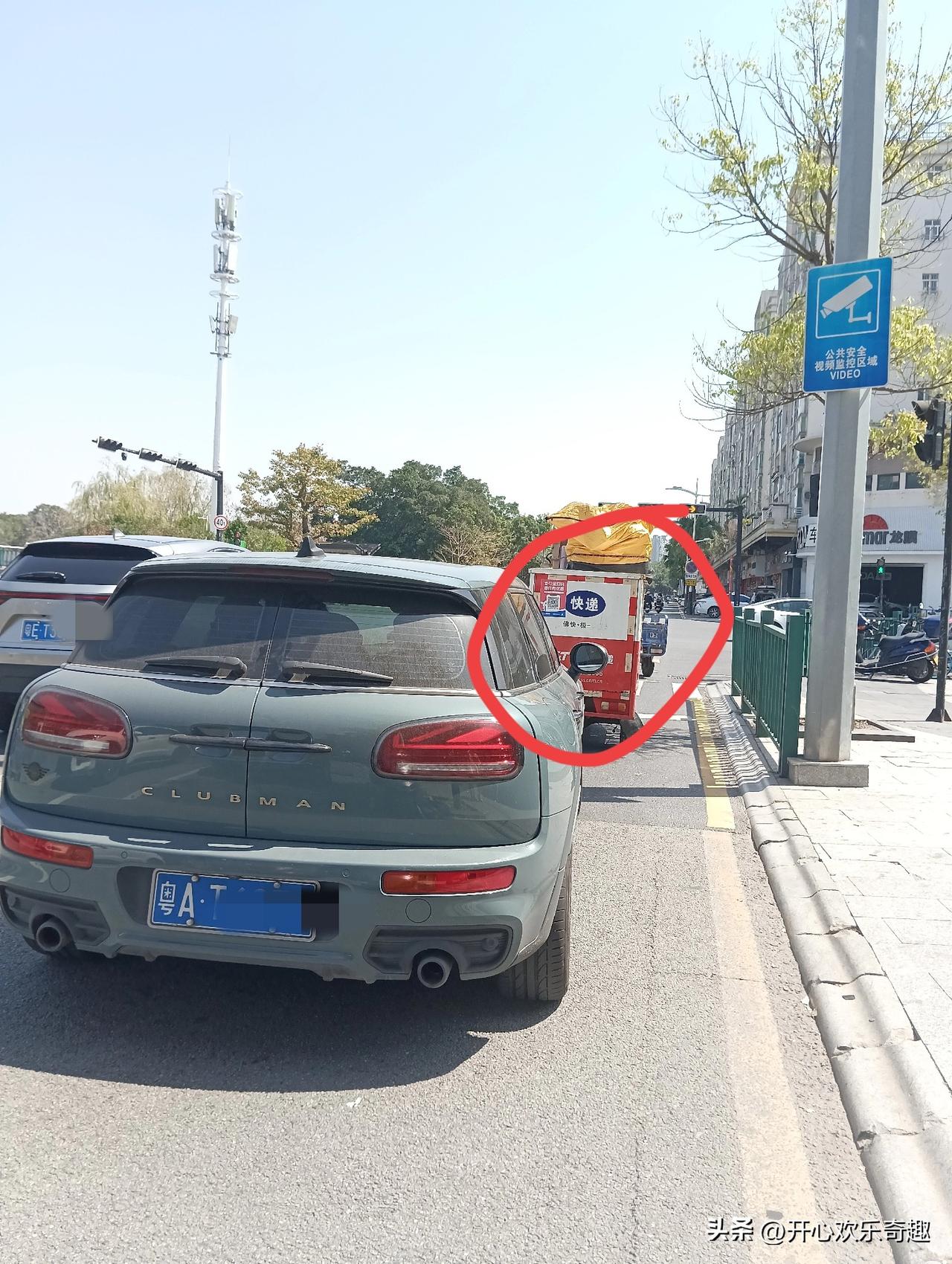 这是遵守交通规则的快递车。在这个红绿灯路口，这个快递车稳稳妥妥的站在了这条斑马线