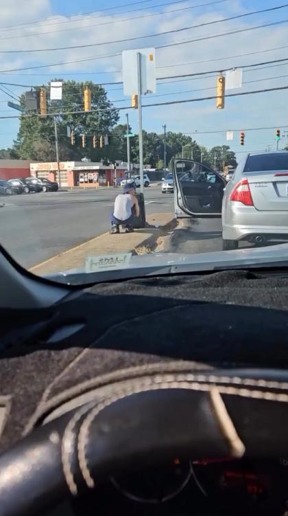 这位北卡罗来纳州的年青司机他在停车等红灯的时候跳下车，并翻一个流浪汉的行李箱。估