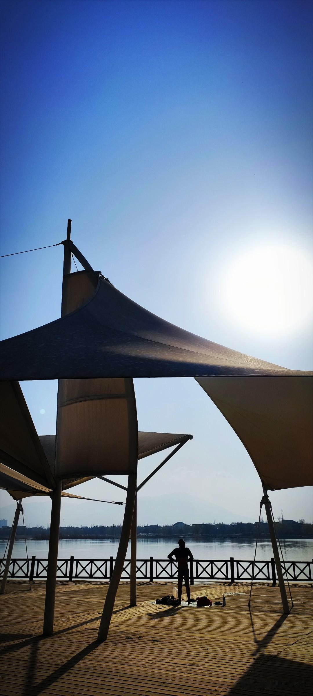 冬日生活打卡季晴好的午后，汉江湿地公园里的小广场上，大爷们光溜溜的穿着小小的泳裤