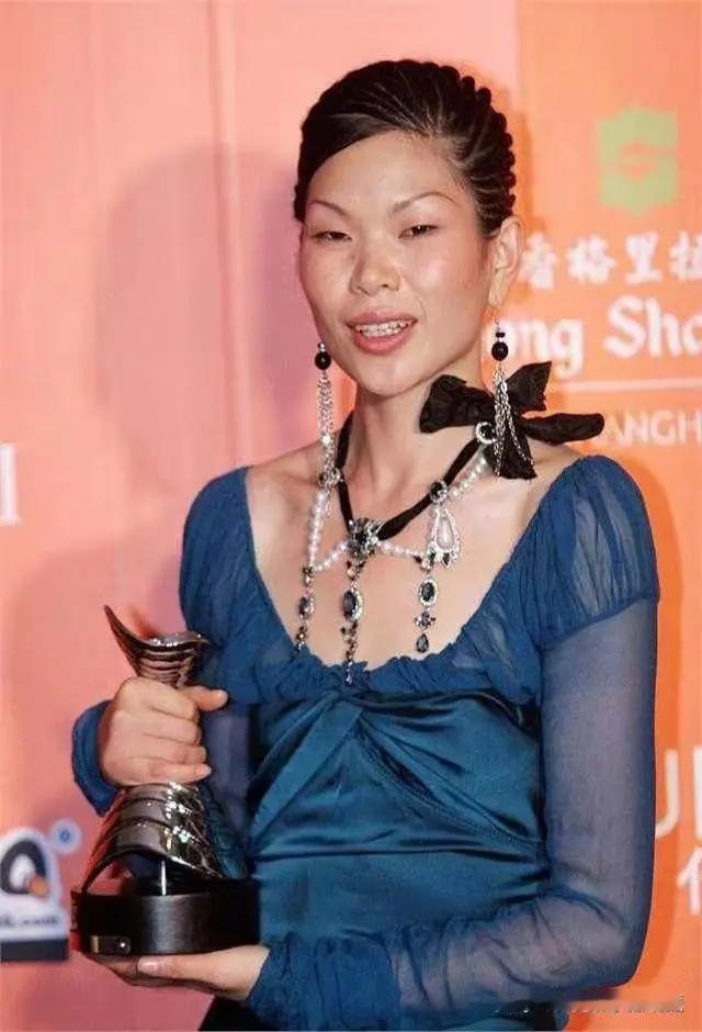 这张图片的主角是中国初代国际超模吕燕，画面里她身着简约黑色上衣，妆容干净，呈现出