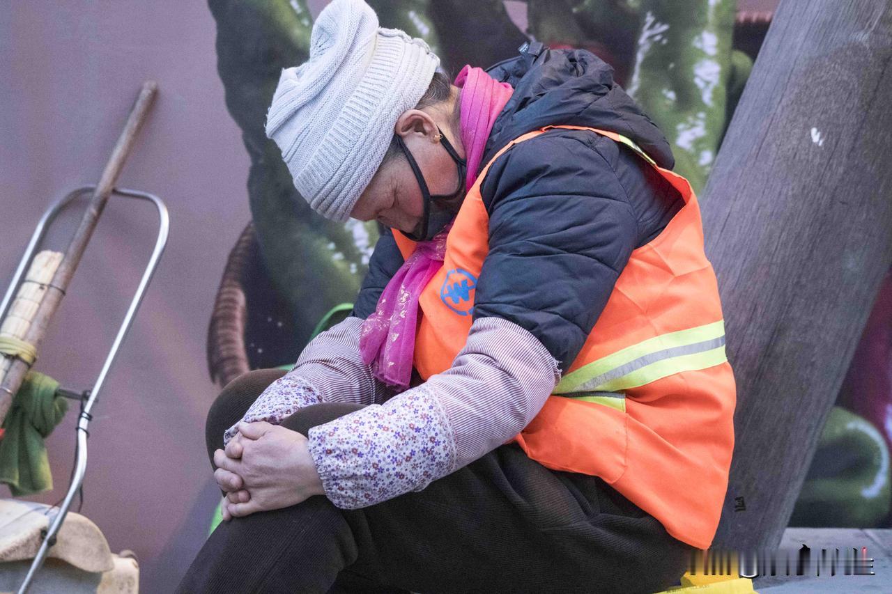 城市还在喧嚣里醒着，她却在街头的一隅，靠着树干蜷起身子，把疲惫揉进短暂的休憩。橙