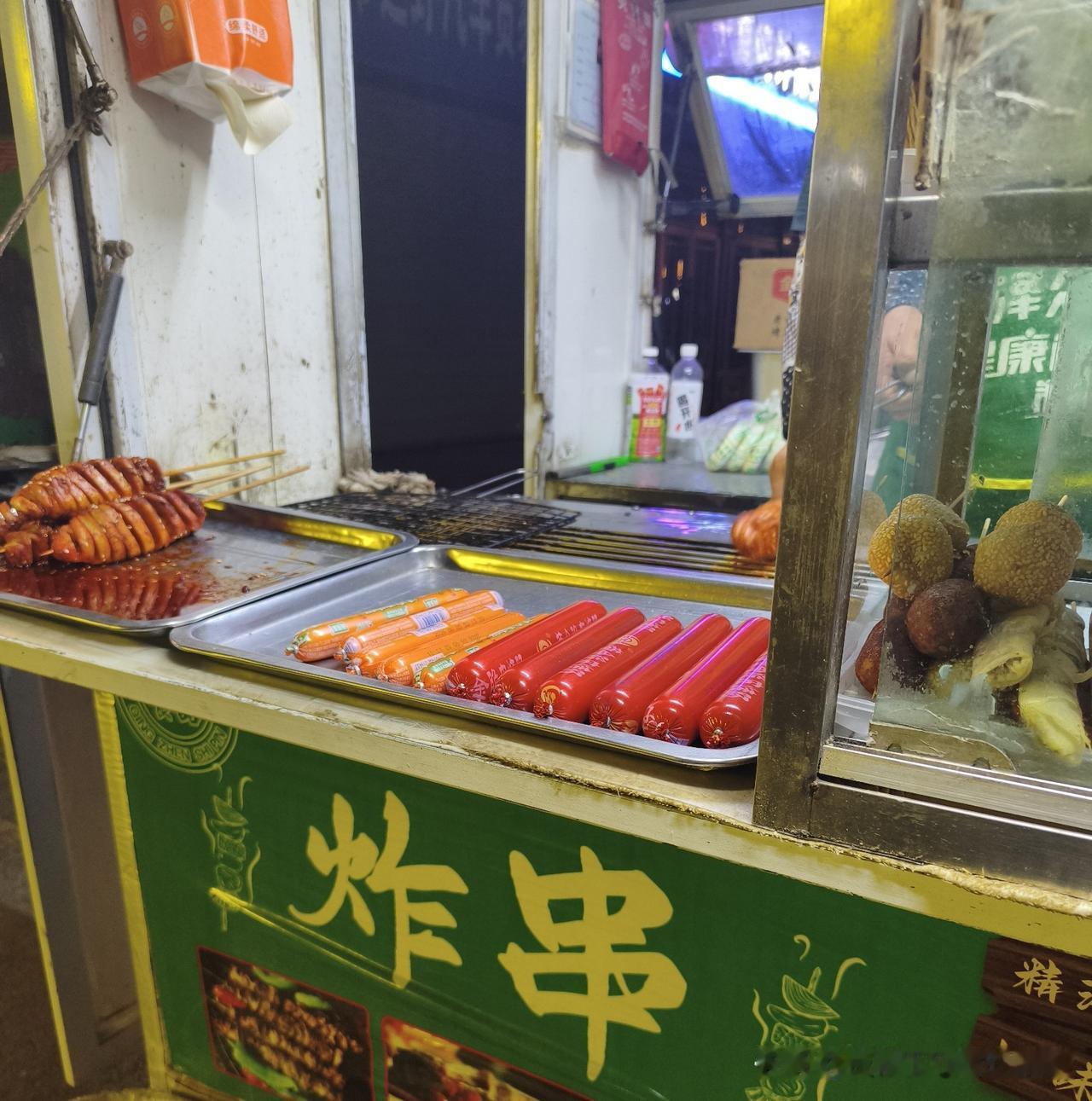 晚上逛夜市路过这家移动炸串小车，瞬间走不动道。

小车简简单单，红肠、脆皮肠、开