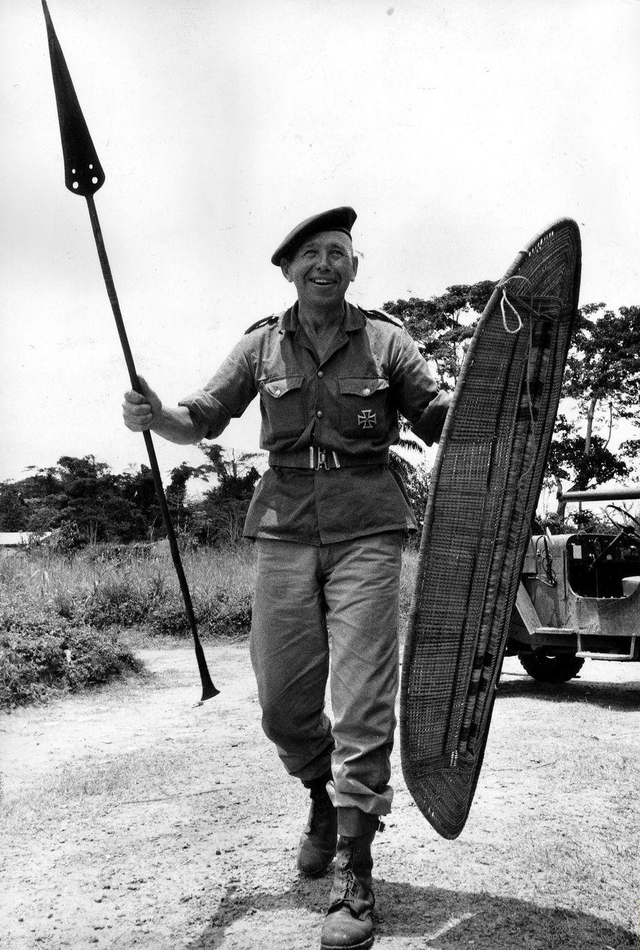 1964年，前二战德国国防军老兵西格弗里德·穆勒手持传统刚果武器在镜头前摆姿势。