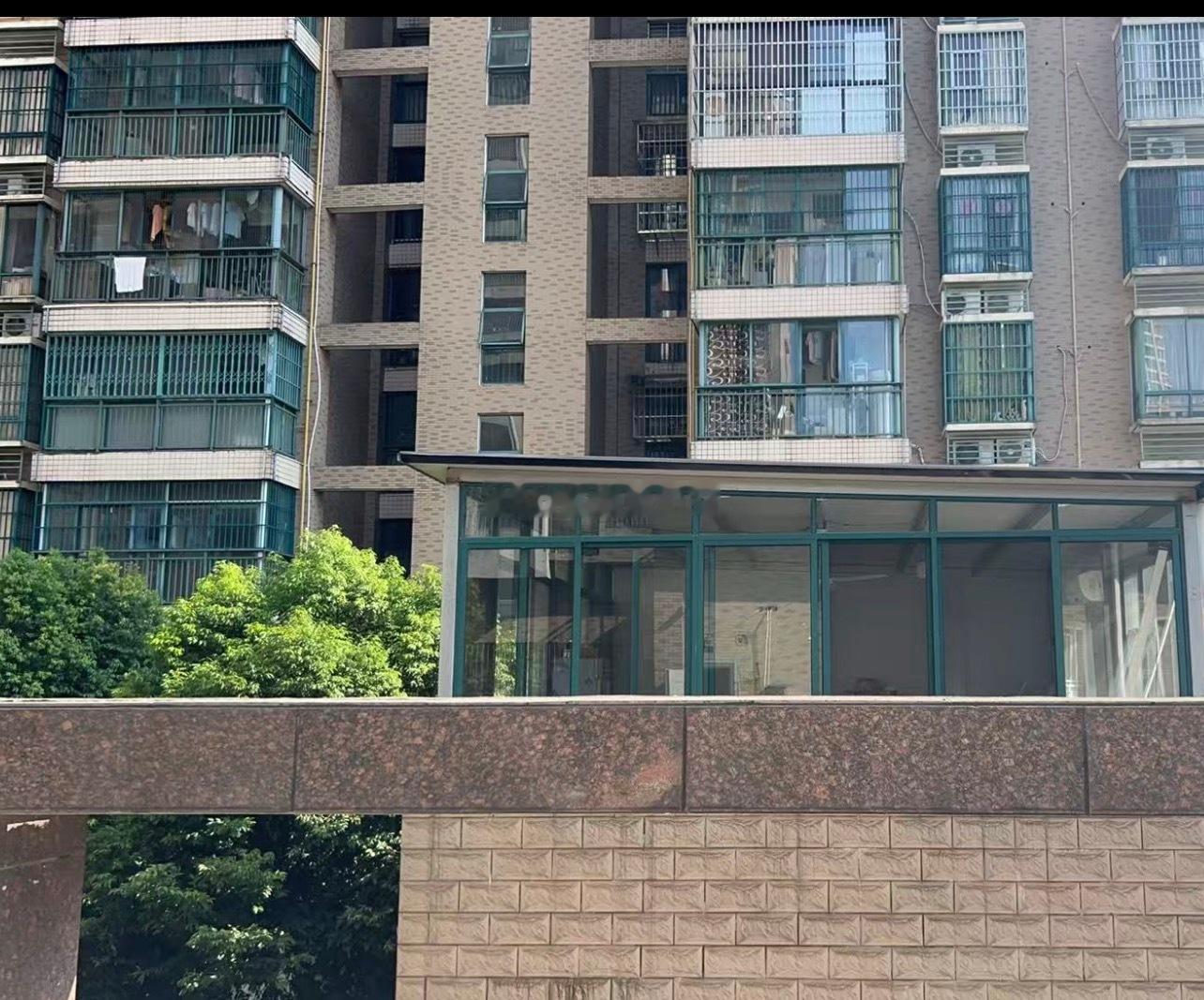 地下停车场出口上方的阳光棚（阳当棚），一半挑出来、一半贴着楼体，高度大概一层半，