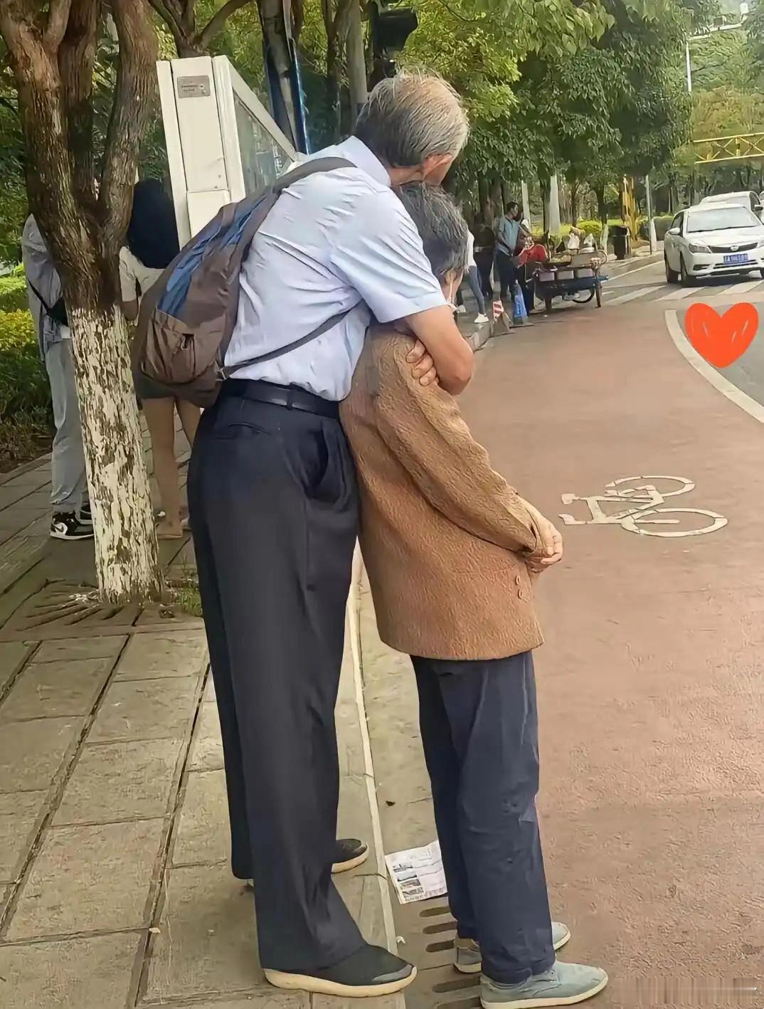 等车的时候，看见一对头发花白的老夫妻，老爷爷从身后环抱住老奶奶，下巴轻轻搭在她的