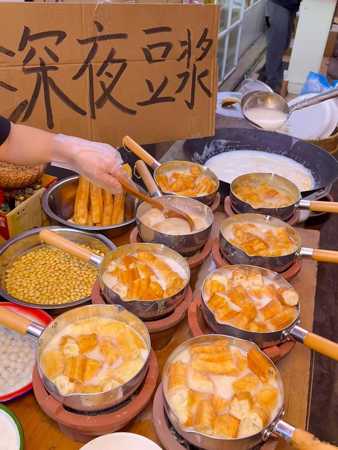 凌晨两点的豆浆摊，油条现炸得金黄酥脆，掰开泡进热豆浆里，三秒吸饱汁水。喝一口甜豆
