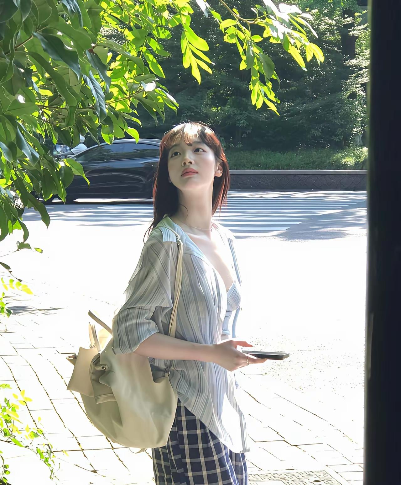 这位姑娘在路边晒太阳，好惬意！