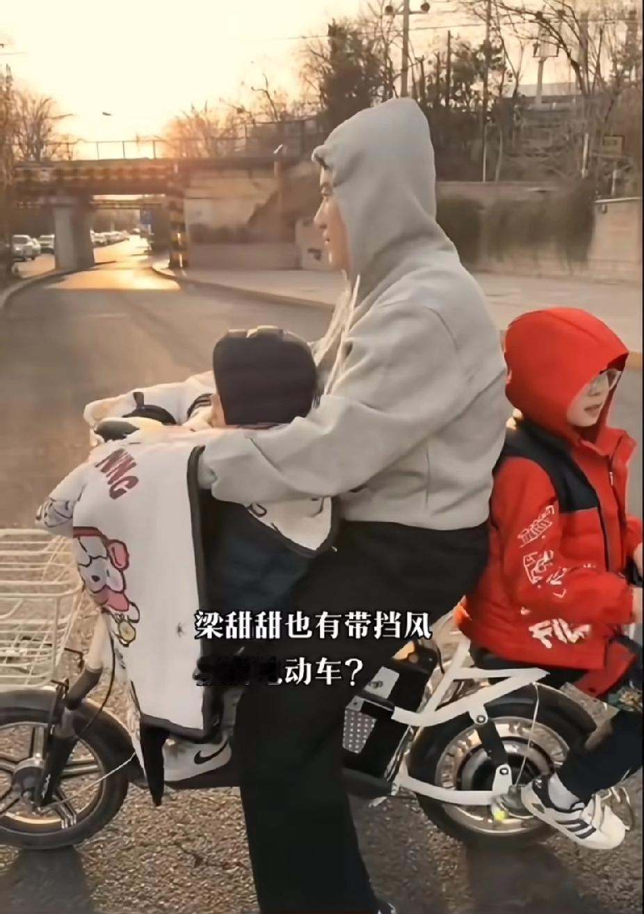 当“大胖”梁靖崑收起了赛场上的锋芒，变身成为“超级奶爸”。
骑着电动车，载着两个