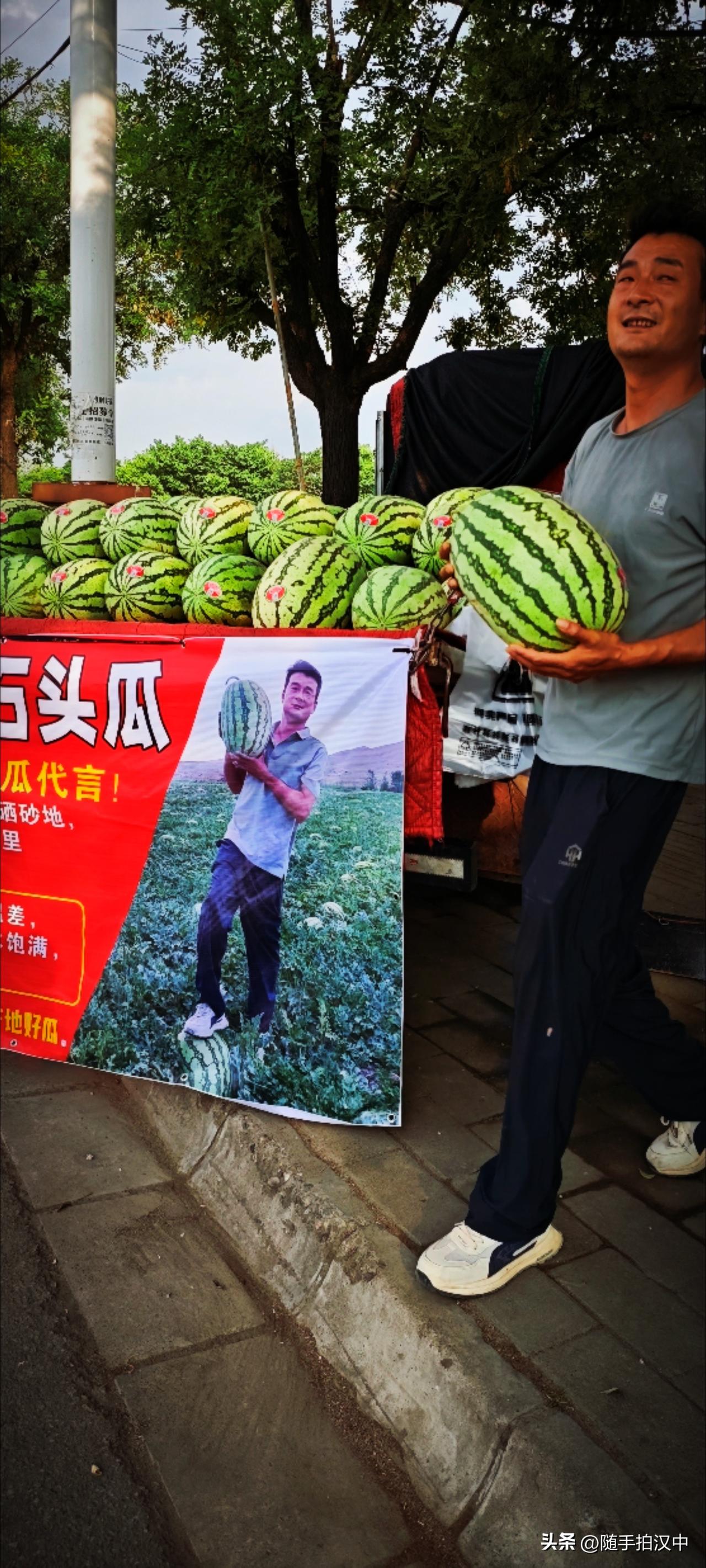路边有个西瓜摊，卡车上铺满西瓜。来买西瓜的人还挺多，谁便一个都有十几斤。老板乐呵