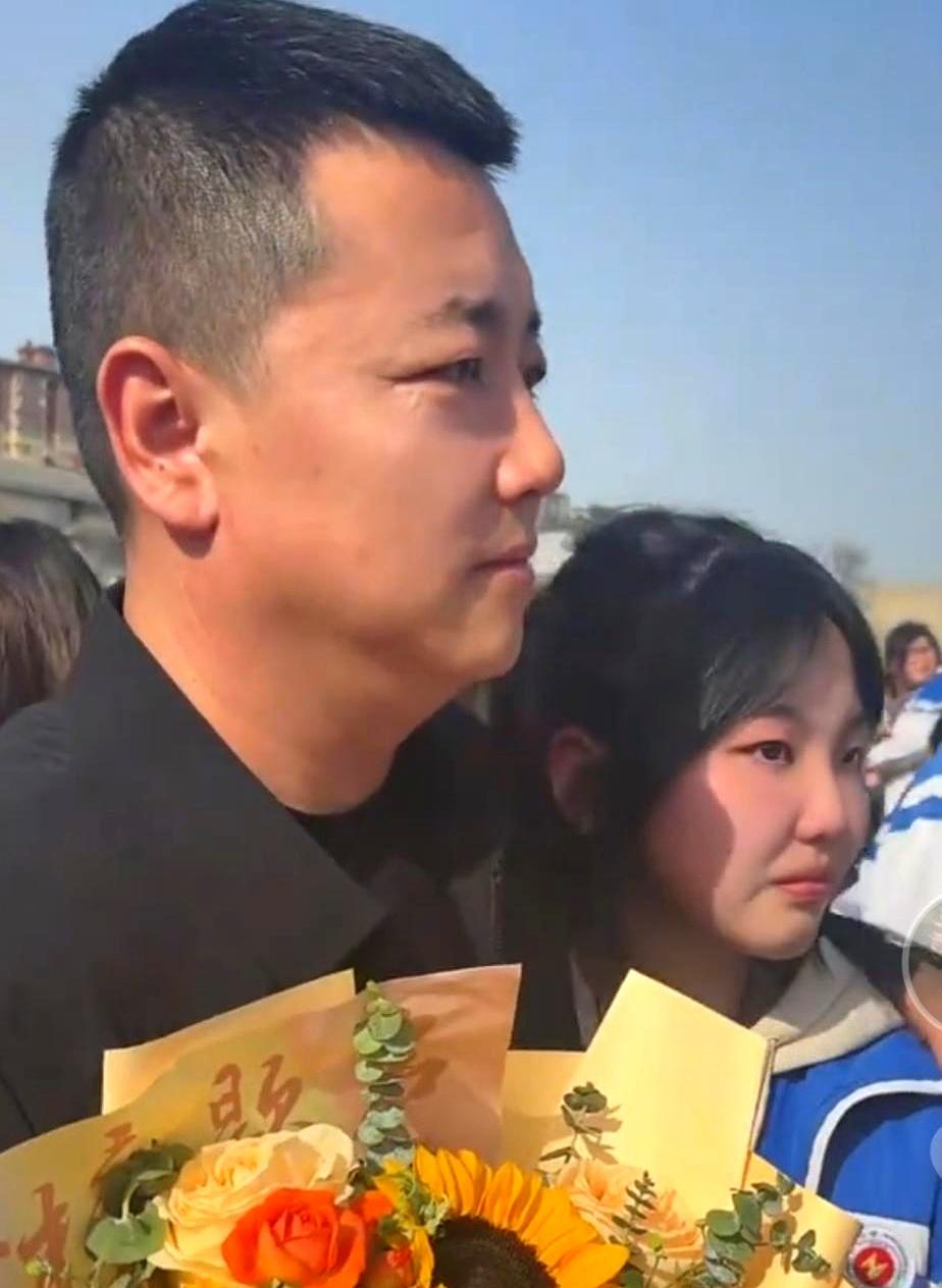 今天刷到一张图，真有点绷不住。
高考誓师大会上，别人身边站的是爸妈，她却是被年轻
