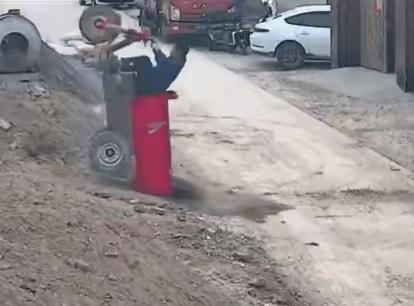 男子开着一个小三轮儿，拉的可能是混凝土要上坡的时候，由于后边太重了，所以车子直接