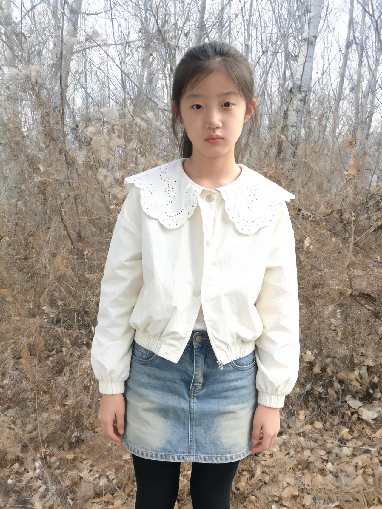 枯树把天空撑成疏朗的丝网
她站在荒草里，白外套的娃娃领
是绽在冬日里的花，镂空的