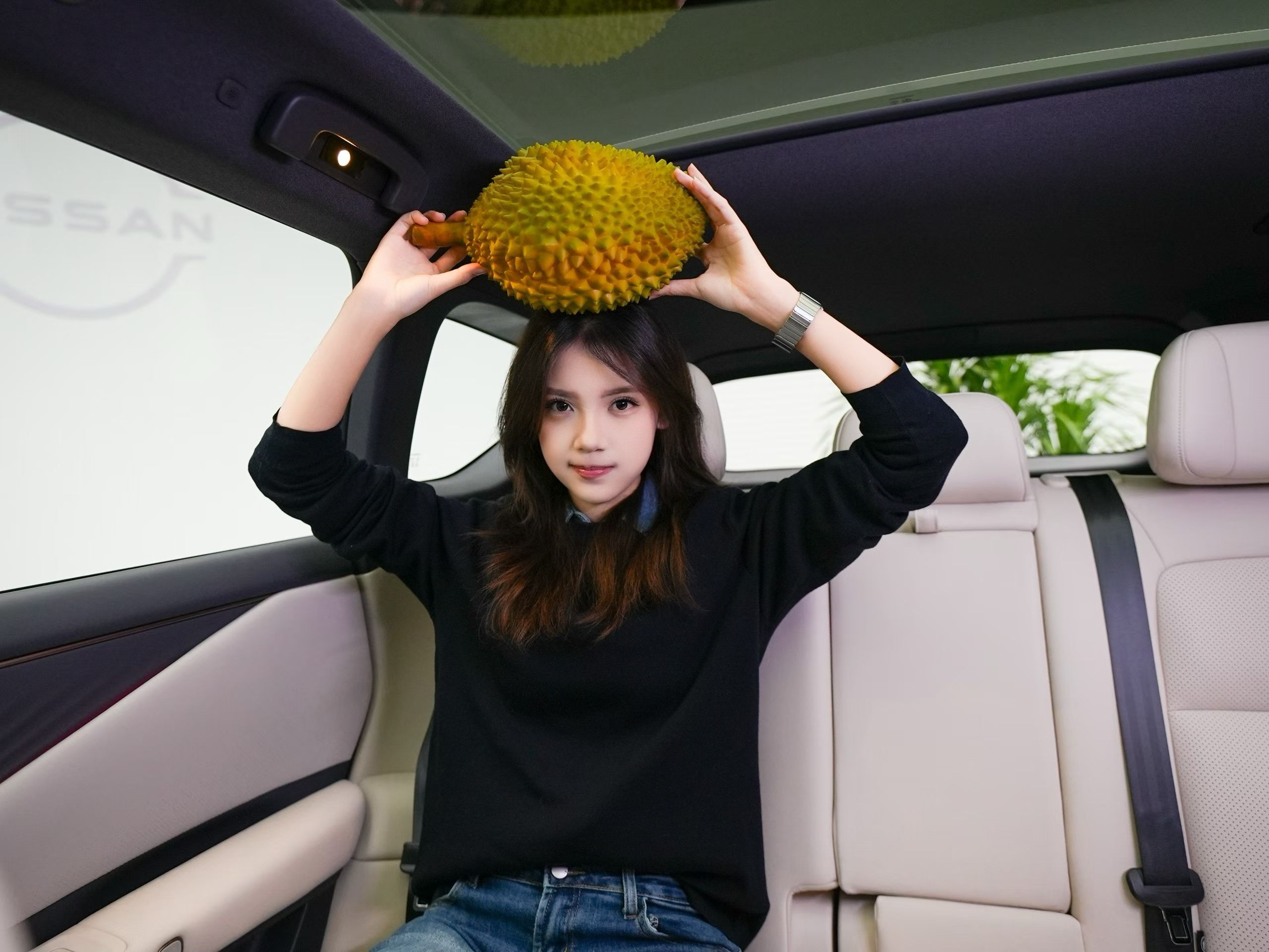 日产NX8后排的顶“榴”空间。给大家找了两位美女的图，感受一下！