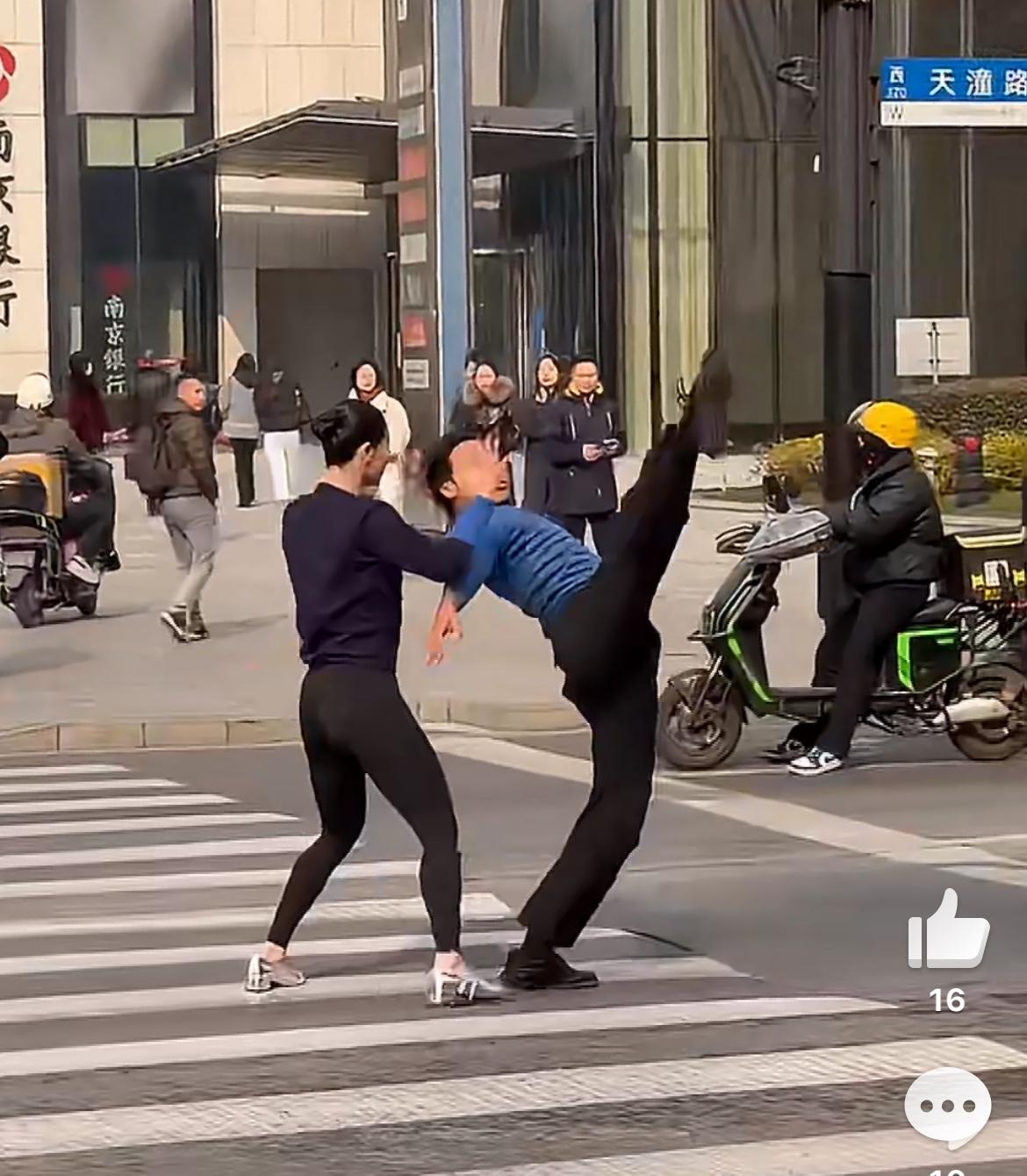 一对男女在斑马线上群魔乱舞，事发上海天潼路，大白天的，车来车往，这明显是主干道，