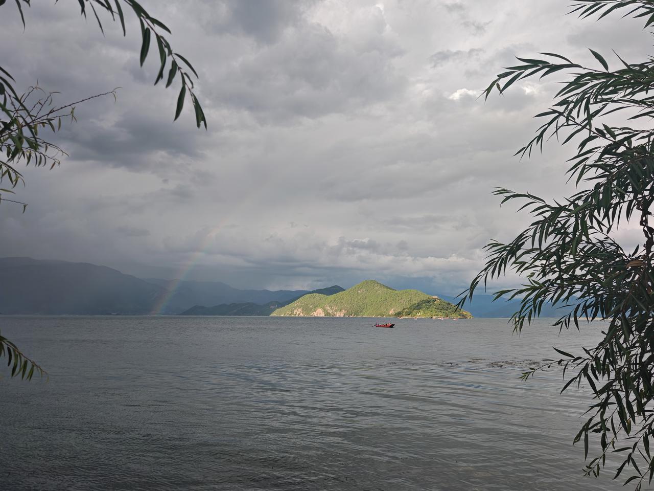 看看你拍的泸沽湖一边淼淼细雨，一边骤然放晴，然后出现一弯彩虹，若隐若现！