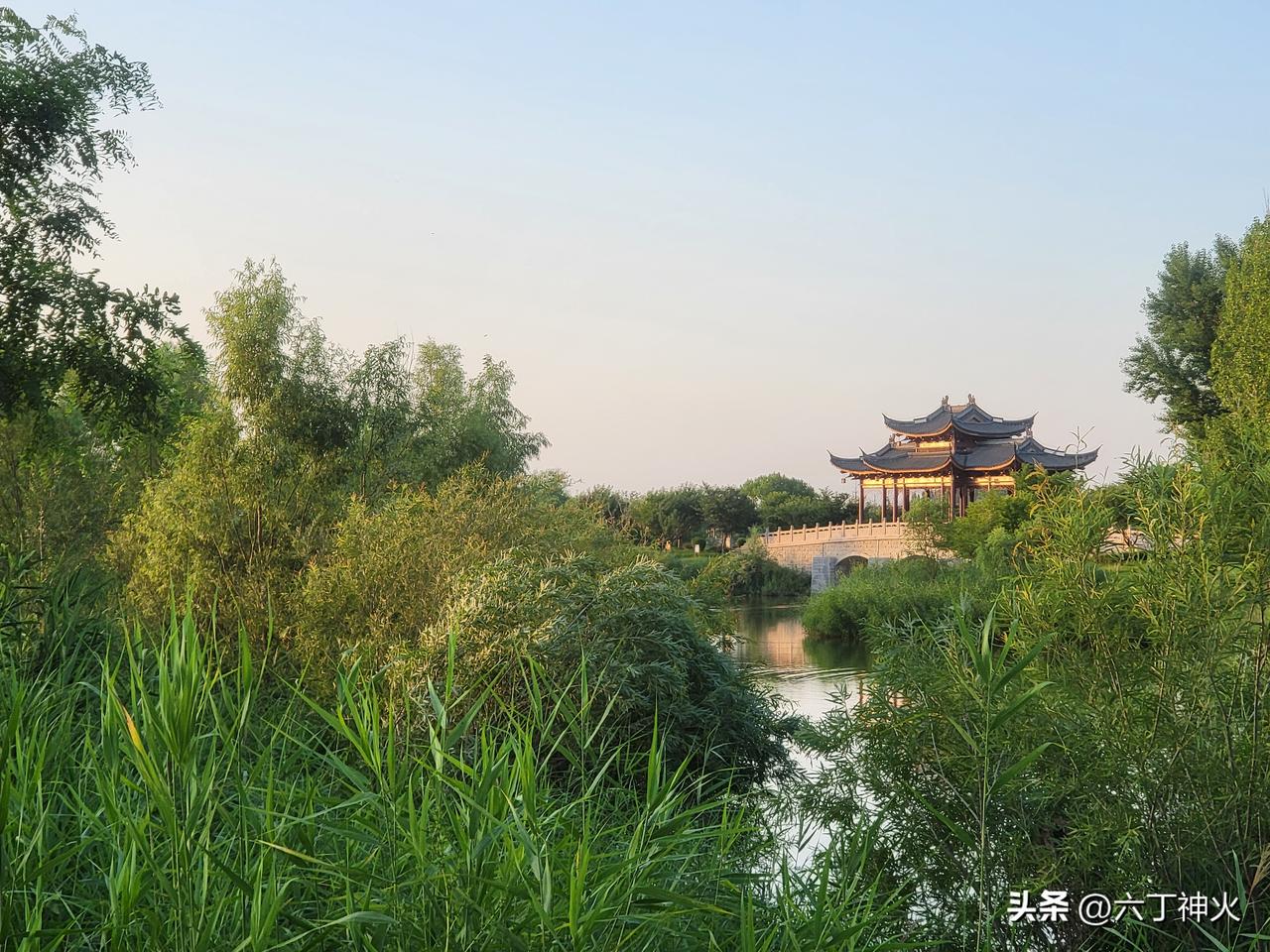 静谧的湖畔边，古风庭院错落分布，恰似一幅淡雅的水墨画。四周绿意葱茏，花草树木于微