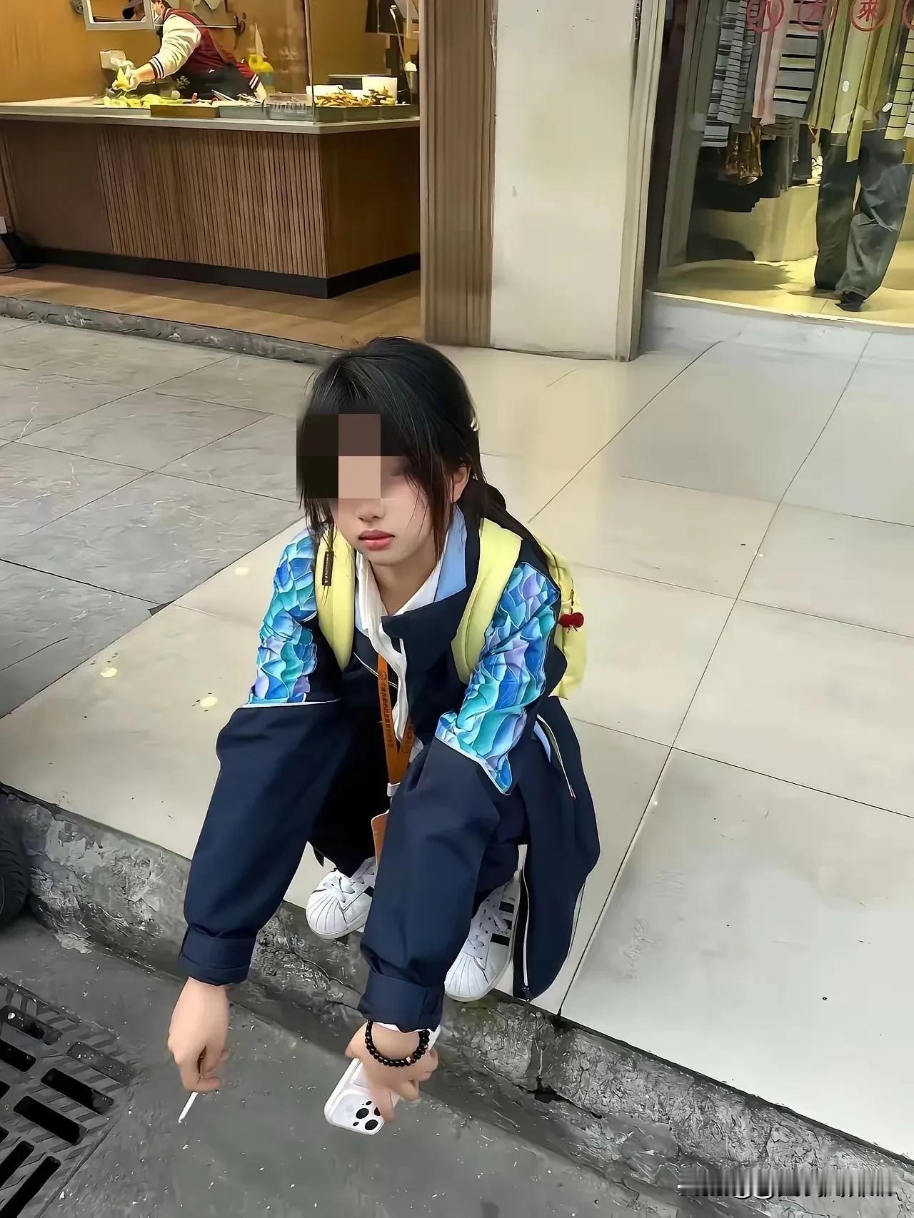 街边蹲着这个女孩，身后背着书包，看来正是上学的年龄，应该是学习上遇到了什么困难？