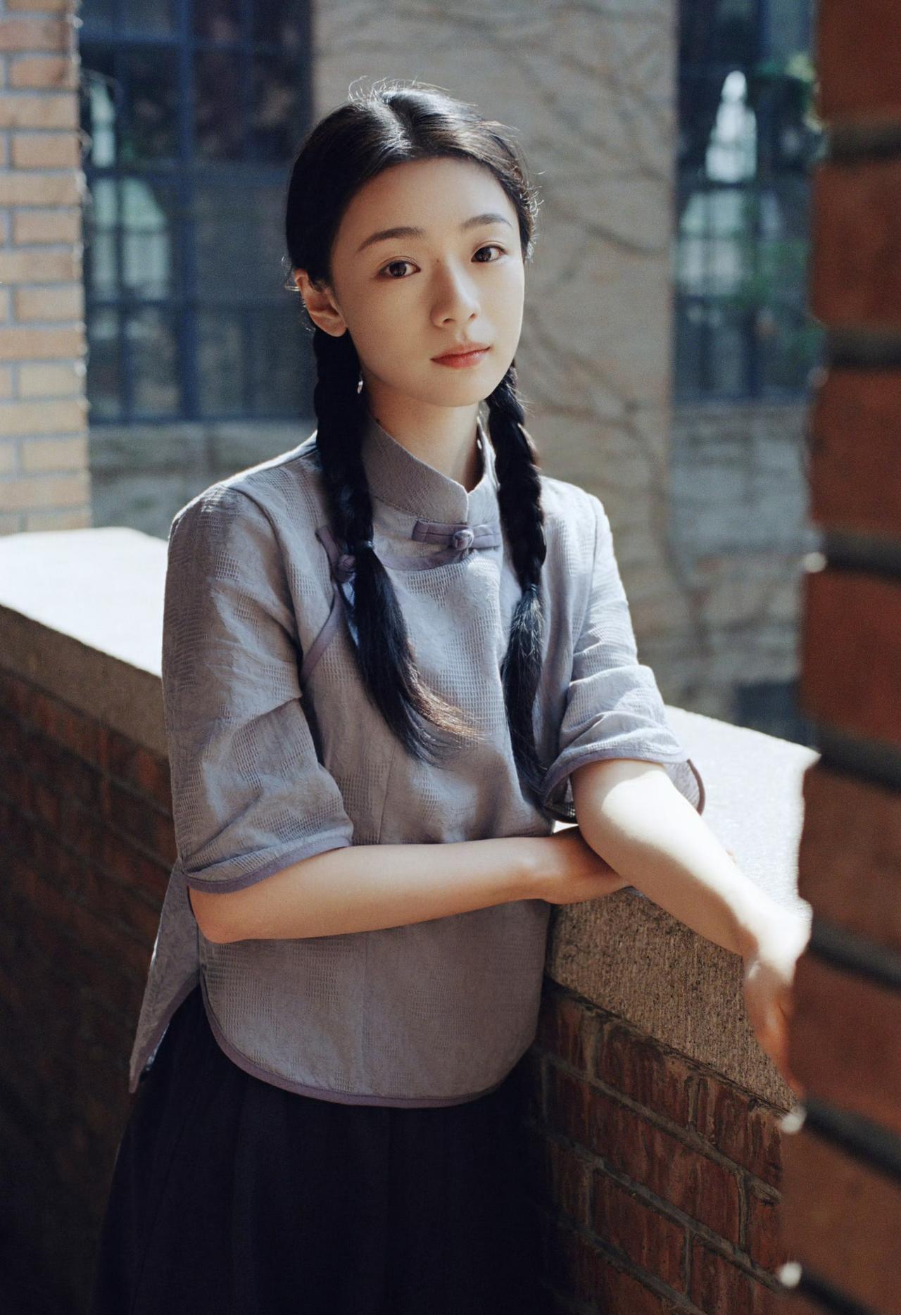 麻花长辫，素色衣衫，青砖墙前日光温柔倾泻。

一纸书卷藏着旧岁心事，一眼清光映着